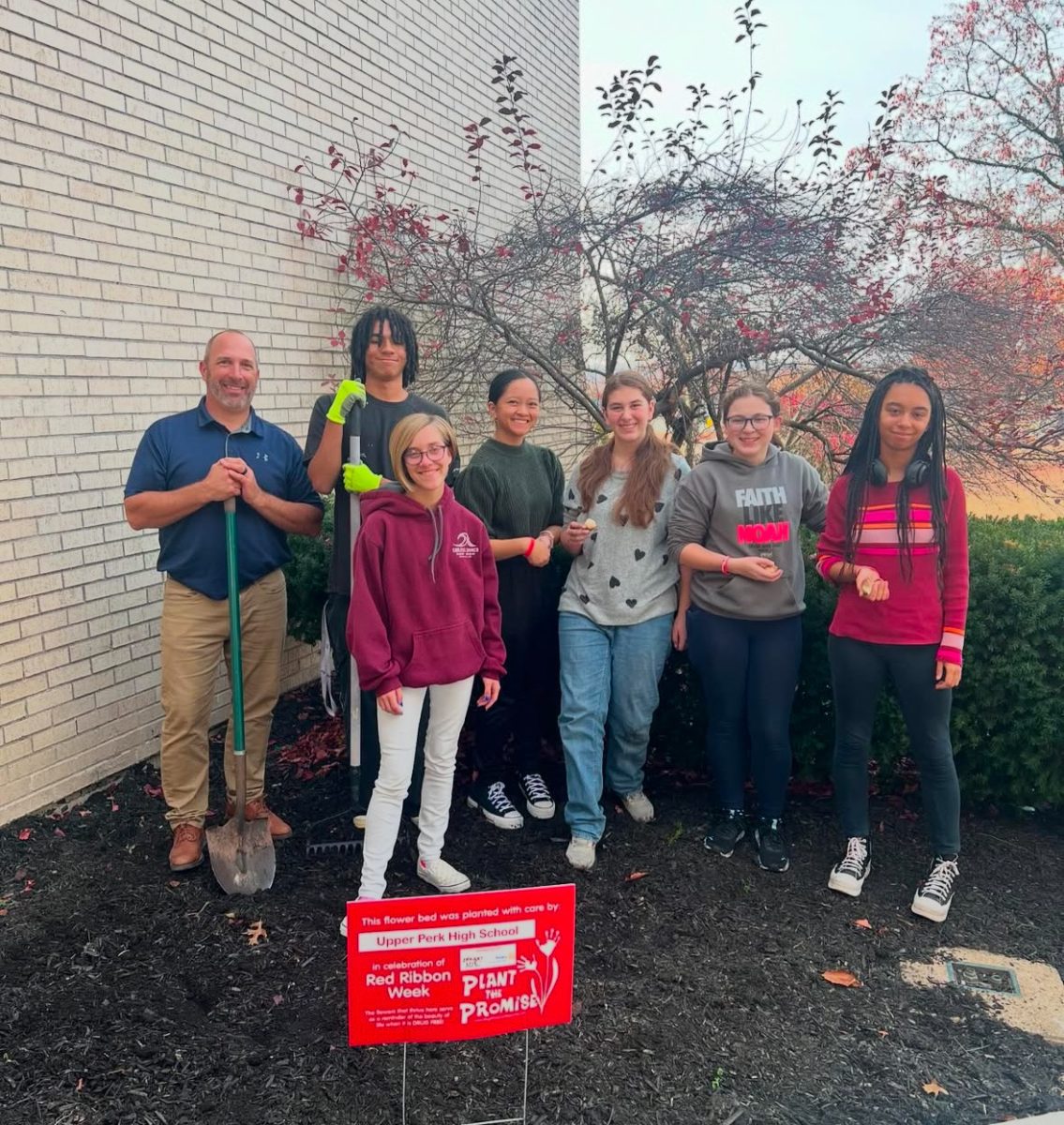 ECC club posing for a picture after planting tulips.