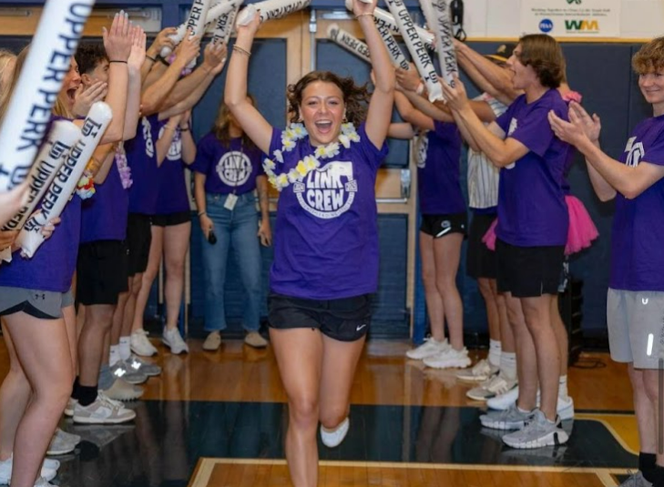 Mia Ulmer runs through the tunnel at freshman orientation. Image pulled from @upperperkiomensd. 