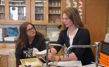 Photo of new Science teacher Mrs Smith helping one of her students. 