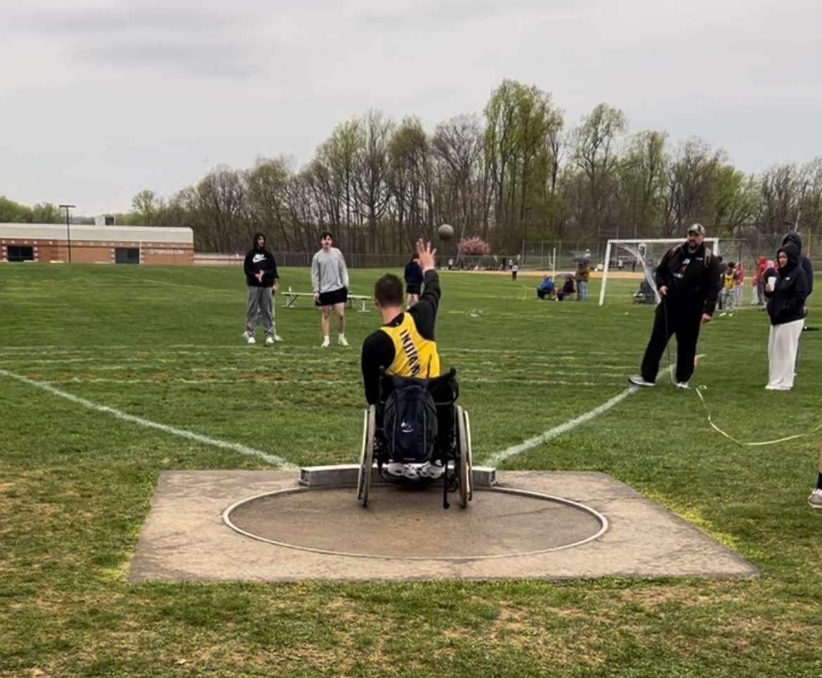 Micah Keller throwing a shot put in his meet. 